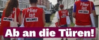 4 Menschen von hinten, die in roten Westen mit weißen Stoffbeuteln und Klemmbrettern durch eine Straße laufen. Auf den Westen steht 